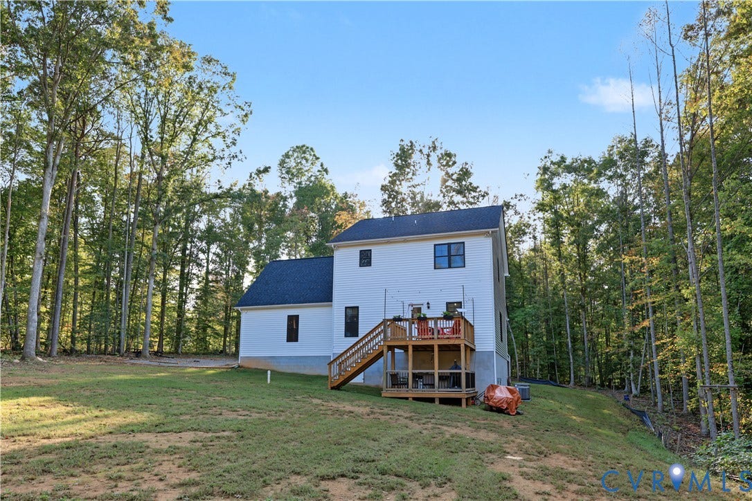 3851 County Line Road, Flemings Mill, Goochland, VA 23084 Two-story exterior with white siding, dark shingle roof, multi-level wood deck, and expansive wooded lot