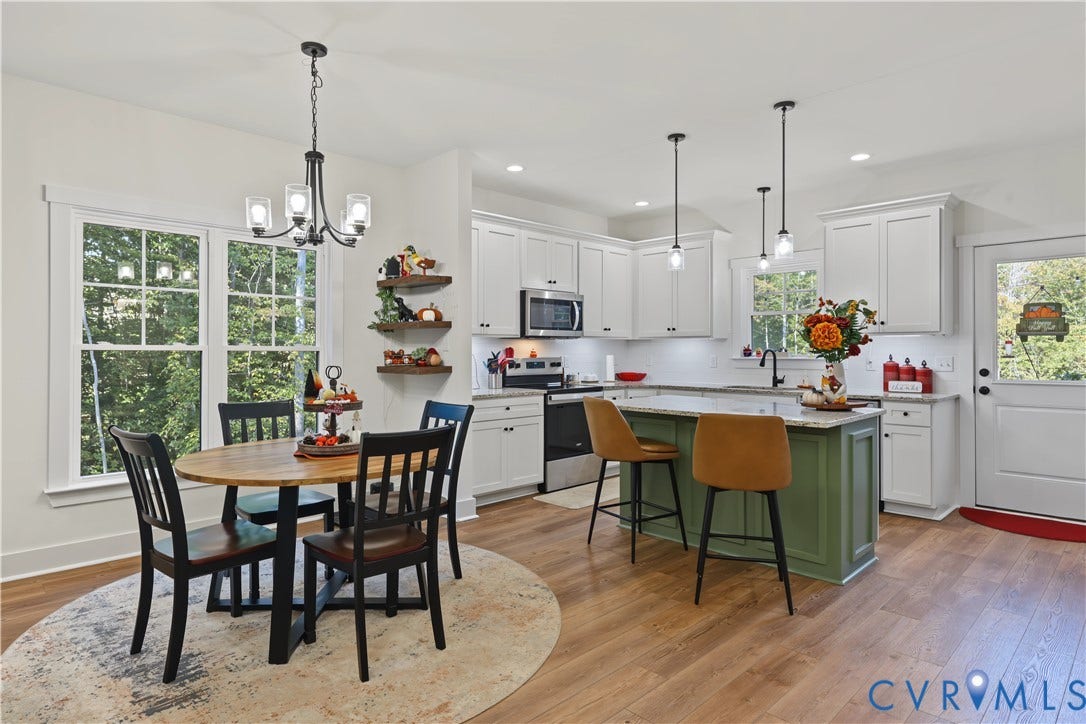 3851 County Line Road, Flemings Mill, Goochland, VA 23084 Kitchen featuring white cabinetry, center island with an olive green base and stone countertop, stainless steel appliances, wood-finish flooring, and pendant lighting