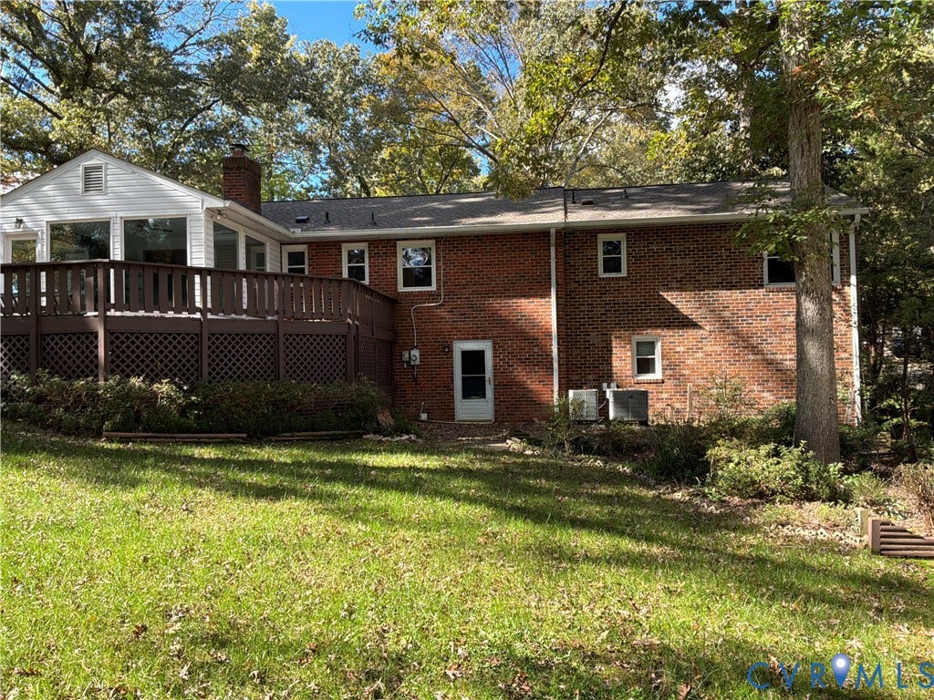 7090 Sunnyside Drive, Mechanicsville, VA 23111 Multi-level exterior featuring a brick facade, elevated wood deck with lattice skirting, shingled roof, and rear-facing windows