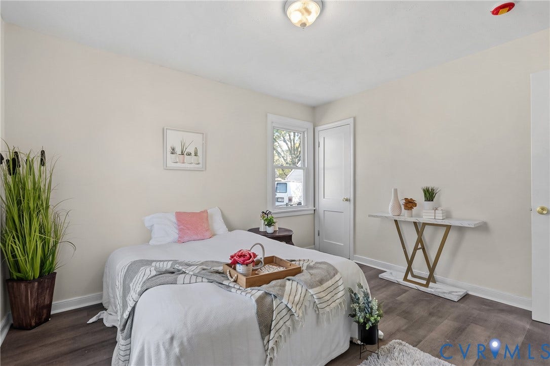 3207 Winchester Street, Henrico, VA 23231 Neutral-toned interior featuring wood-finish flooring, a double-hung window, and a single-panel interior door with satin-finish hardware