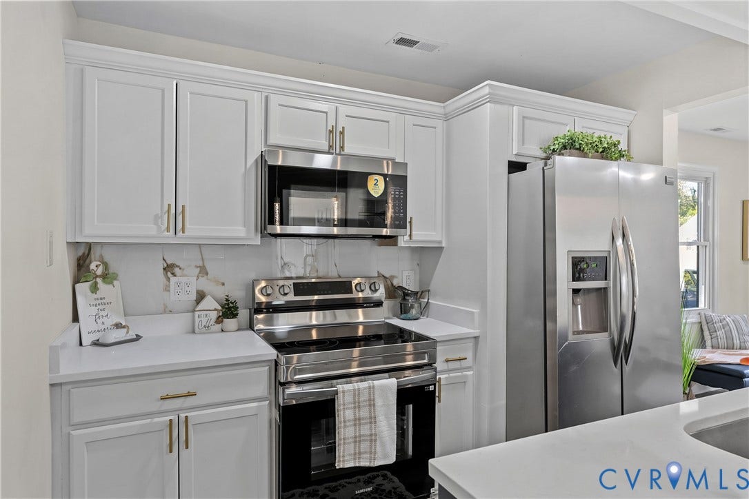3207 Winchester Street, Henrico, VA 23231 Kitchen featuring white shaker-style cabinetry with brass-finish pulls, solid surface countertops, stainless steel appliances, and a built-in microwave