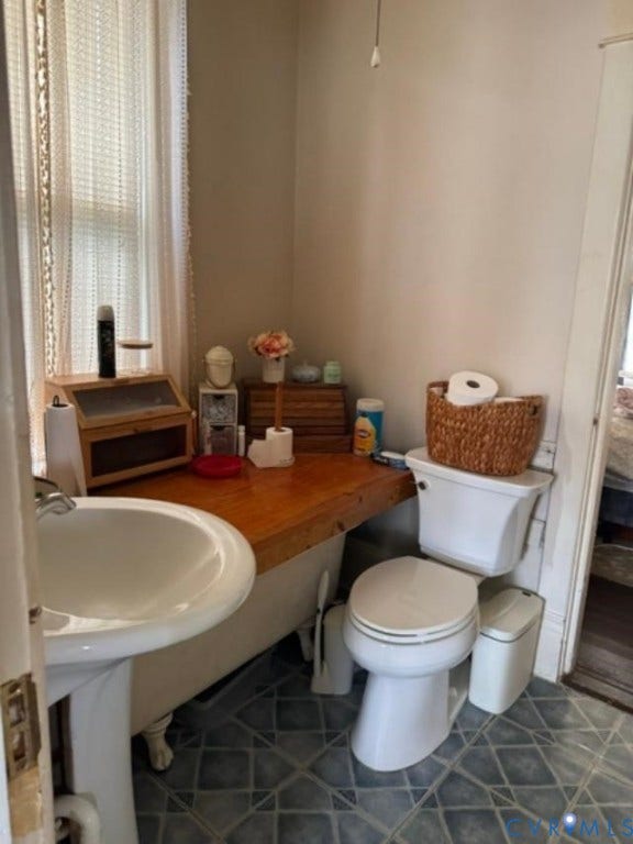 18194 S. Railroad Avenue, Boykins, VA 23827 Claw-foot tub, white pedestal sink, and patterned flooring