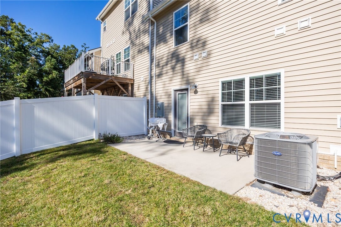 12548 Petrel Crossing, Midlothian, VA 23112 Vinyl-sided exterior featuring an elevated deck with a white railing, a concrete ground-level patio, and white privacy fencing