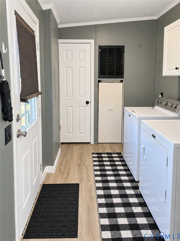 Laundry area featuring wood-finish flooring, crisp white cabinetry, a dedicated exterior door with integrated window pane, and solid-core interior door
