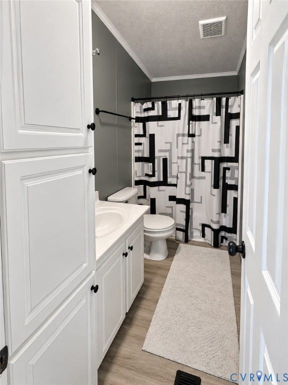 Full-height white built-in cabinetry, white vanity with integrated sink, matte black hardware, and wood-finish flooring