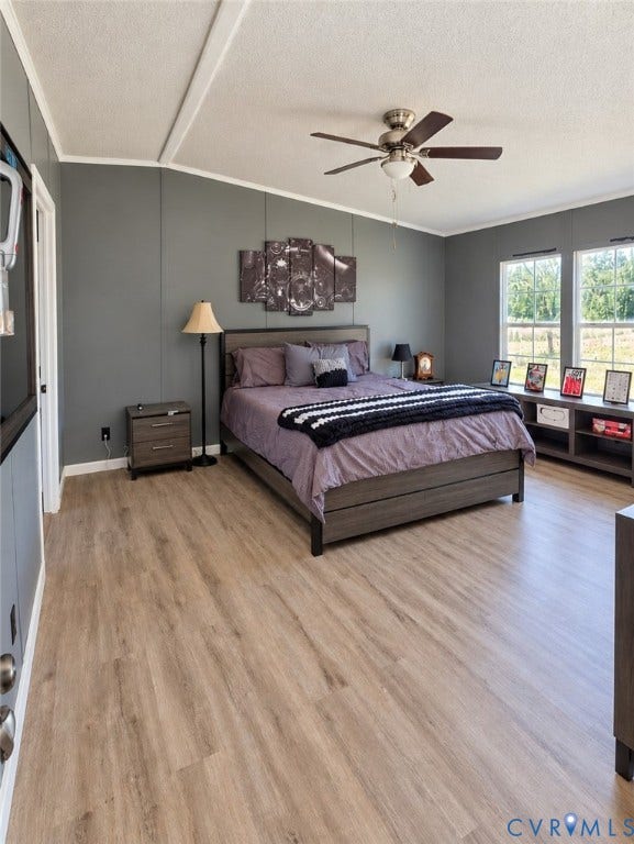 Room featuring wood-finish flooring, dual windows, matte grey wall panels, and a central ceiling fan with an integrated light fixture