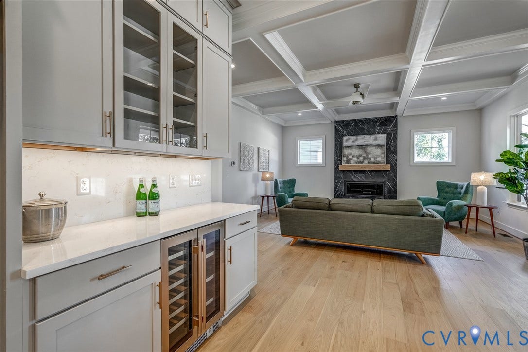 12101 Blunt's Bridge Estates Court, Blunt's Bridge Estates, Doswell, VA 23047 Coffered ceilings, wood-finish flooring, built-in cabinetry with glass-front uppers, quartz countertops, and a full-height stone-surround fireplace