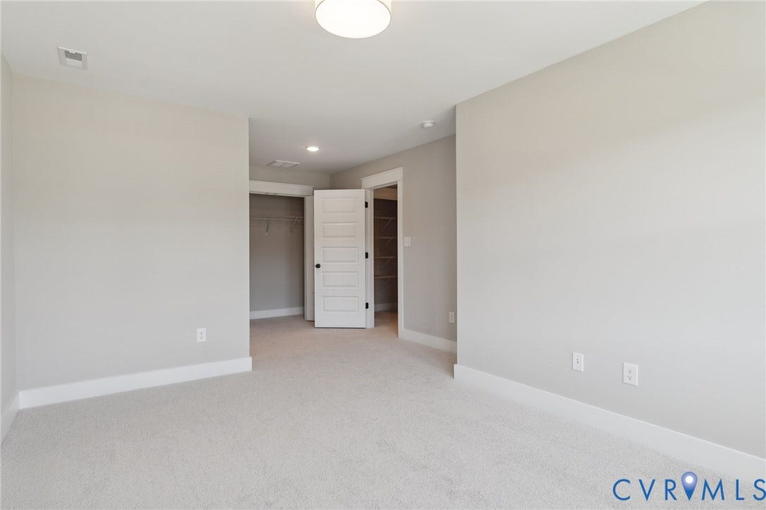 9131 Terroir Lane, Viniterra Villas, New Kent, VA 23124 Neutral interior featuring wall-to-wall carpeting, a four-panel interior door, and built-in closet shelving