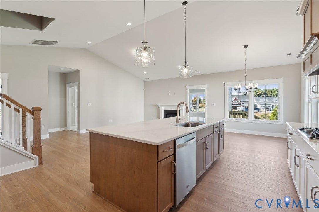9131 Terroir Lane, Viniterra Villas, New Kent, VA 23124 Kitchen featuring a center island with a stone-finish countertop, stainless steel dishwasher, vaulted ceiling, wood-finish flooring, and pendant lighting