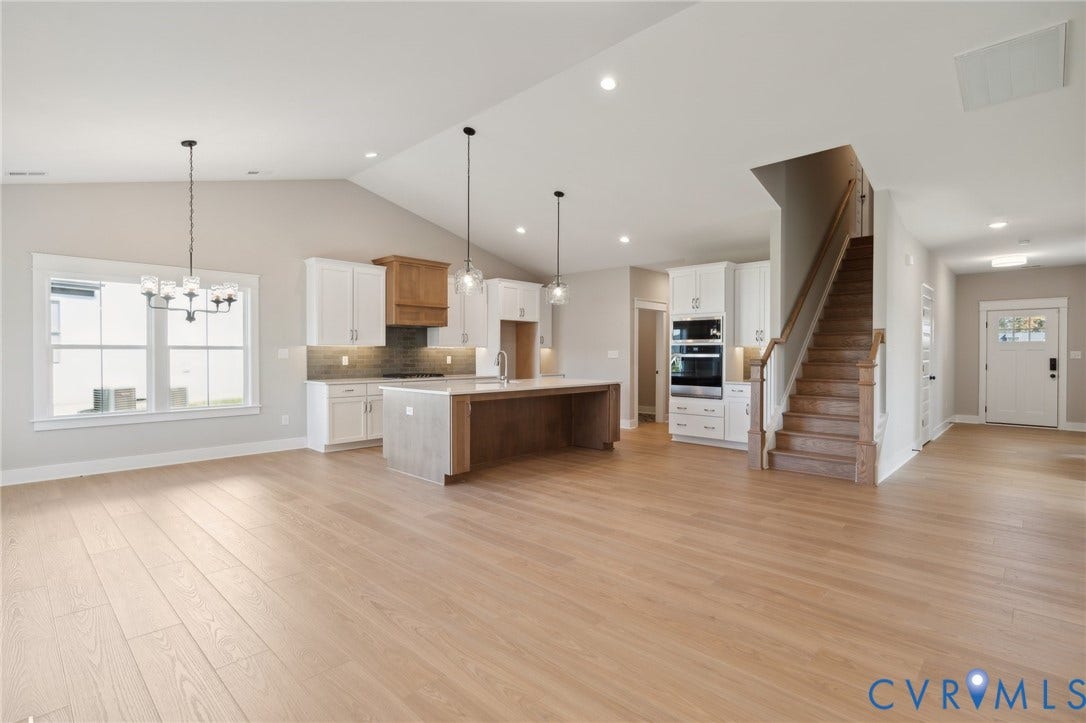 9131 Terroir Lane, Viniterra Villas, New Kent, VA 23124 Vaulted ceiling, wood-finish flooring, kitchen island with cabinetry, built-in double wall oven, and wood-finish staircase