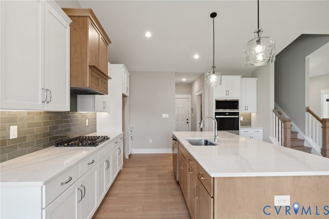 9131 Terroir Lane, Viniterra Villas, New Kent, VA 23124 Kitchen featuring two-tone cabinetry, quartz countertops, a subway tile backsplash, a gas cooktop, and built-in wall oven