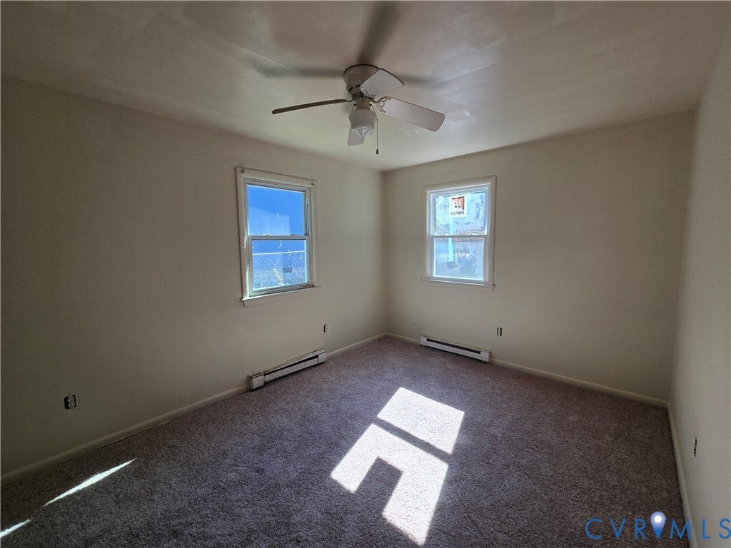 320 Shore Street, Petersburg, VA 23803 Interior room featuring neutral-toned carpeting, two windows, and a ceiling-mounted fan with light fixture