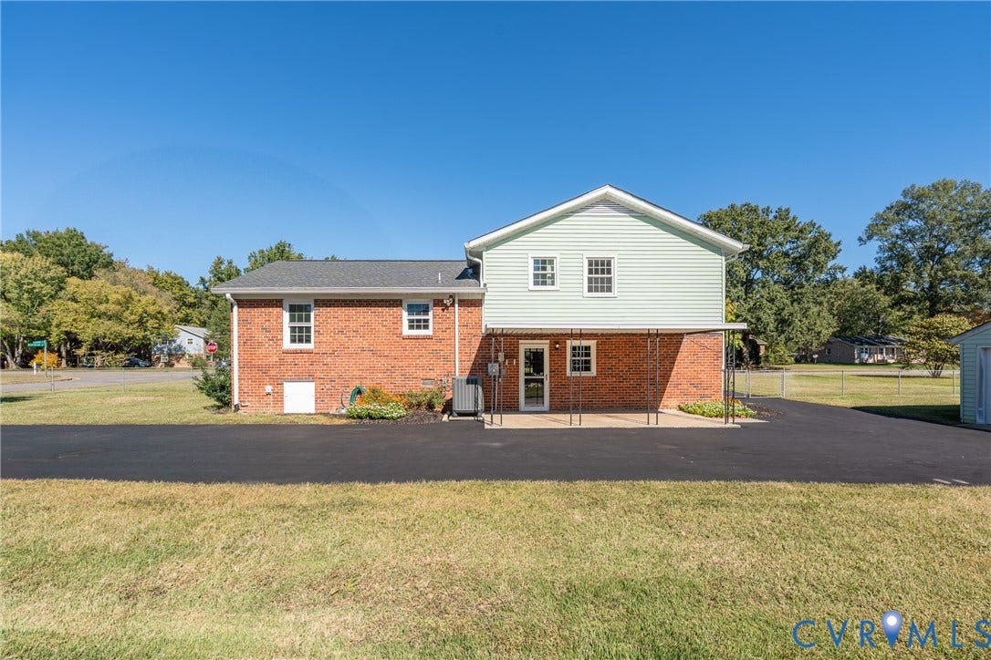 9329 Totopotomoy Trail, Ashland, VA 23005 Exterior featuring a combination of brick and lap siding, a covered concrete patio, and an asphalt driveway