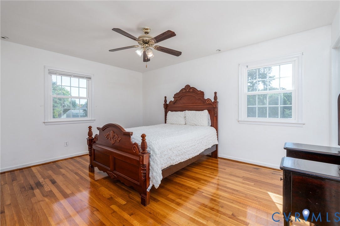9329 Totopotomoy Trail, Ashland, VA 23005 Room featuring wood-finish flooring, two double-hung windows with muntins, and a ceiling fan with integrated lighting