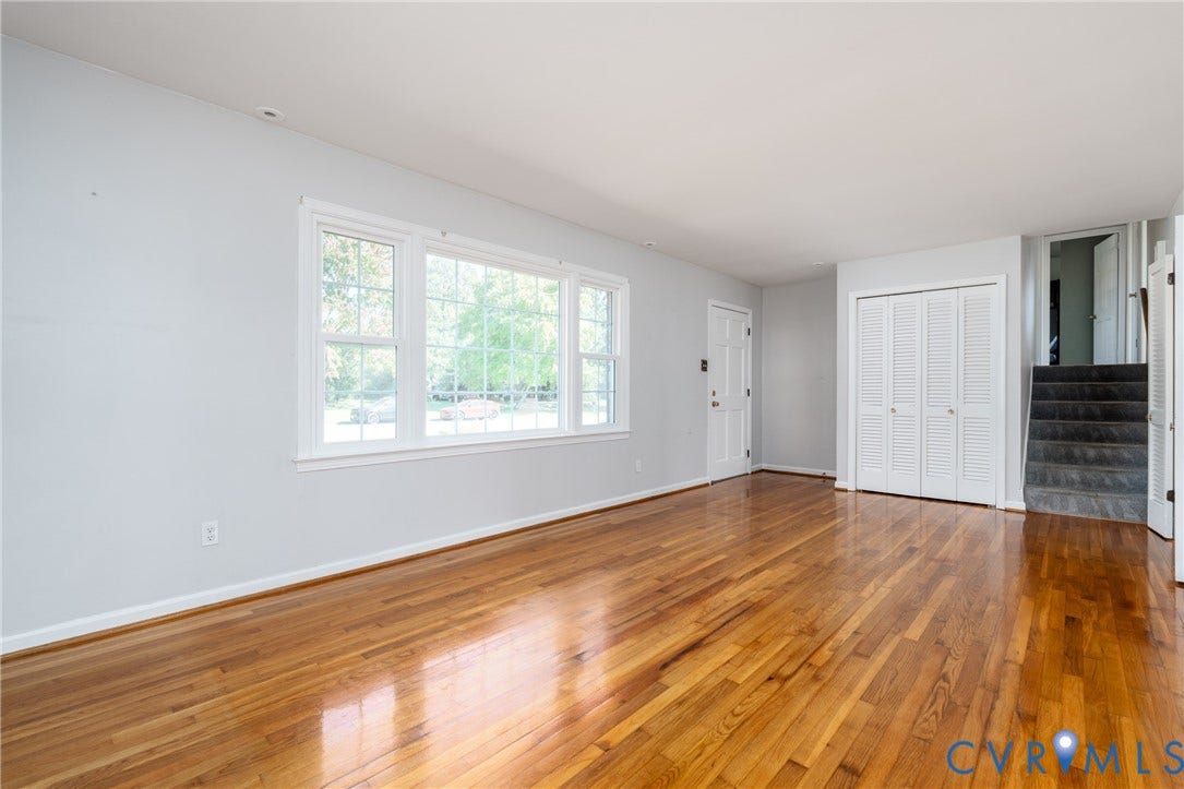 9329 Totopotomoy Trail, Ashland, VA 23005 Living area featuring wood-finish flooring, large multi-pane windows, and white bifold closet doors