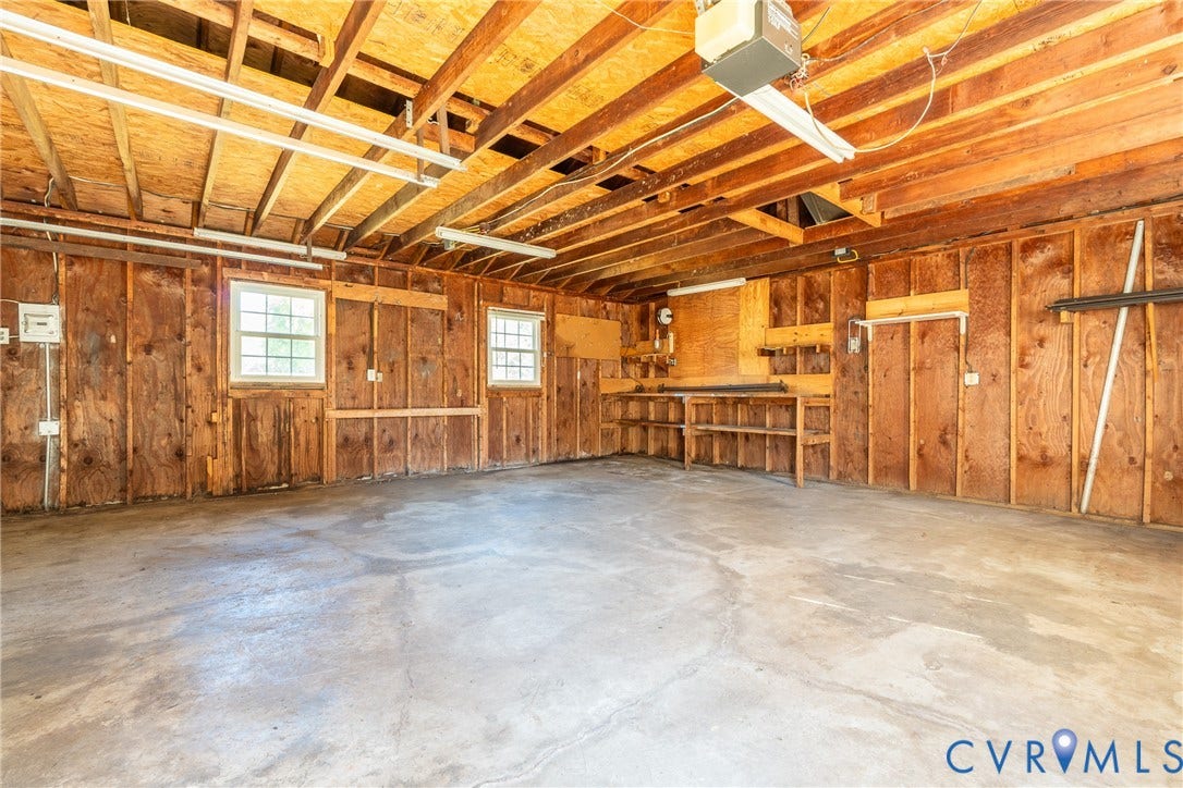 9329 Totopotomoy Trail, Ashland, VA 23005 Garage space featuring exposed beam construction, concrete flooring, double-hung windows, and built-in shelving