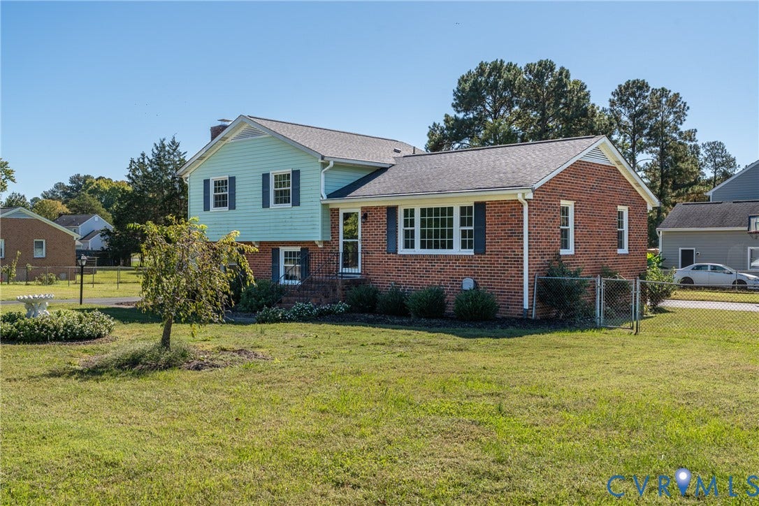 9329 Totopotomoy Trail, Ashland, VA 23005 Two-story brick and lap siding exterior featuring multi-pane windows, a gabled roofline, and a fenced yard