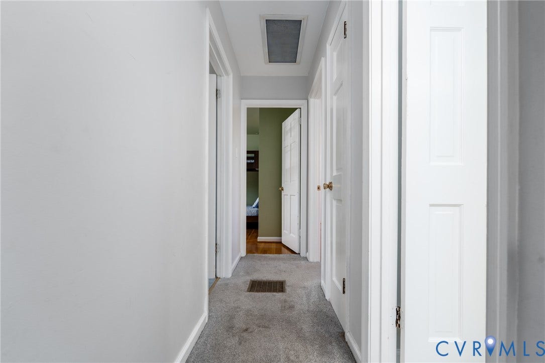 9329 Totopotomoy Trail, Ashland, VA 23005 Interior hallway featuring multi-panel interior doors, neutral wall paint, and carpeted flooring