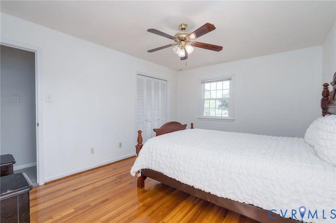 9329 Totopotomoy Trail, Ashland, VA 23005 Room featuring wood-finish flooring, a ceiling fan with integrated lighting, a double-panel closet with louvered doors, and a multi-pane window