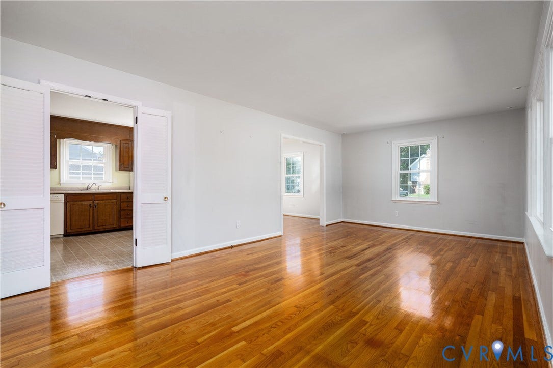 9329 Totopotomoy Trail, Ashland, VA 23005 Interior space featuring polished wood-finish flooring, neutral wall paint, multi-pane windows, and white-paneled bi-fold doors
