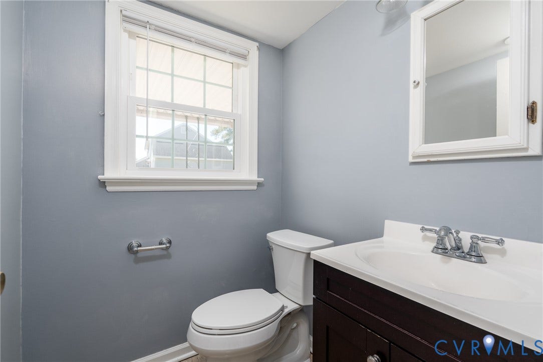 9329 Totopotomoy Trail, Ashland, VA 23005 Dark wood vanity with a white countertop, integrated sink, chrome double-handle faucet, and white-framed medicine cabinet