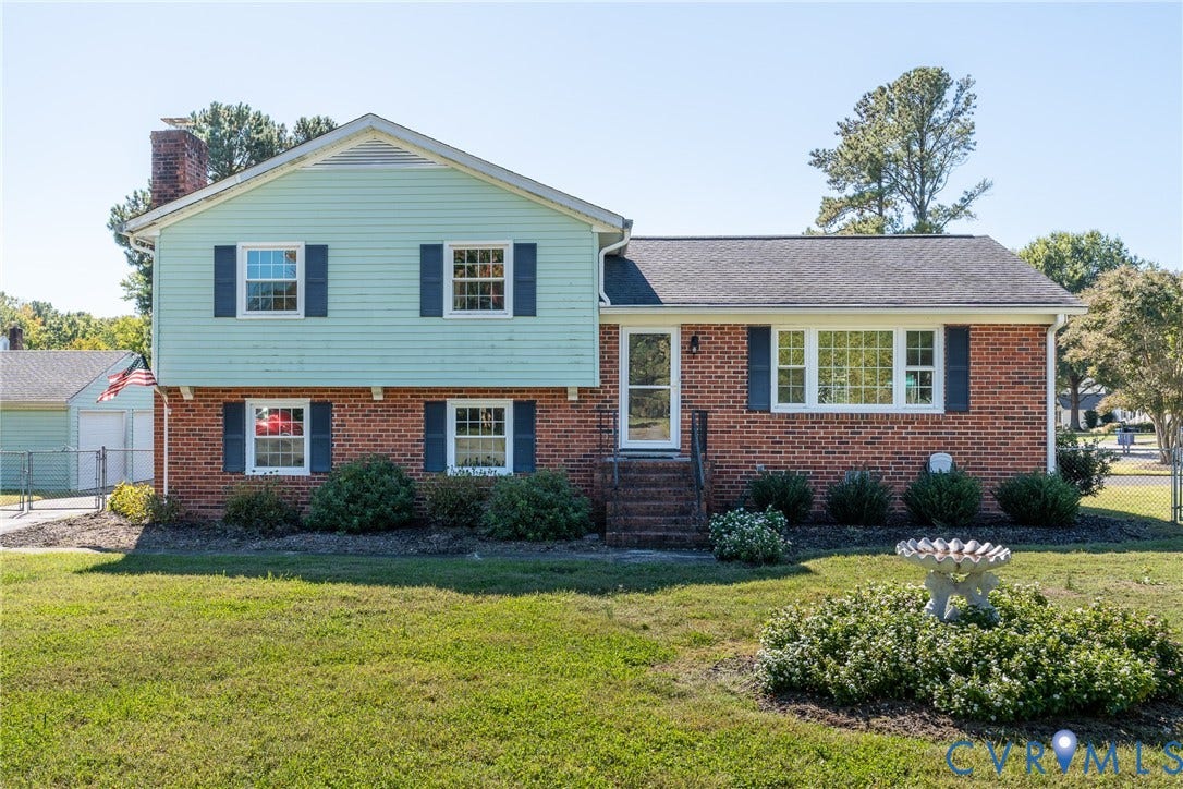 9329 Totopotomoy Trail, Ashland, VA 23005 Split-level exterior featuring a brick and siding facade, chimney, dark shutters, and front landscaping