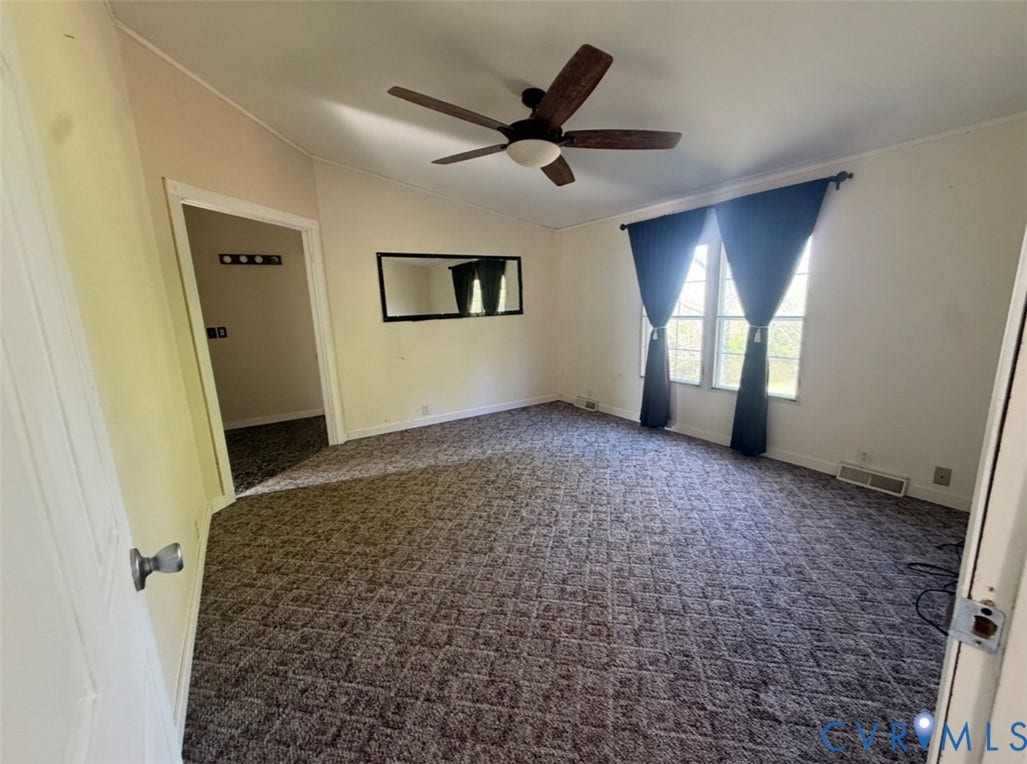 26691 Bell Road, Amelia, VA 23002 Spacious room featuring vaulted ceilings, a central multi-blade ceiling fan with integrated lighting, wall-to-wall patterned carpeting, and large dual windows