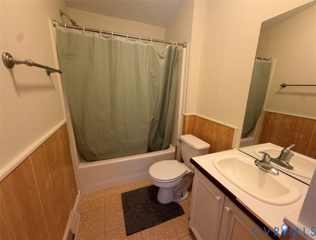 26691 Bell Road, Amelia, VA 23002 Bathroom featuring wood-paneled walls, vanity with integrated basin, chrome-finish plumbing fixtures, and a tub-shower combination