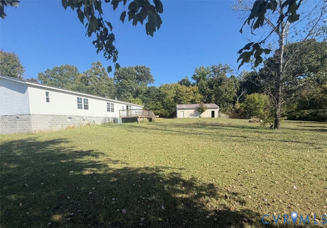 26691 Bell Road, Amelia, VA 23002 Expansive grounds featuring a wood deck, detached structure, concrete block foundation, and mature trees