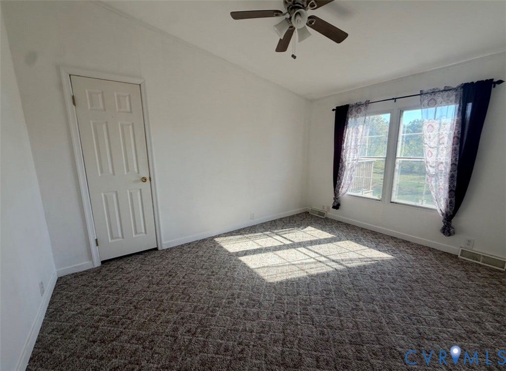 26691 Bell Road, Amelia, VA 23002 Vaulted ceiling room featuring neutral carpeting, a multi-blade ceiling fan with integrated lighting, and dual windows