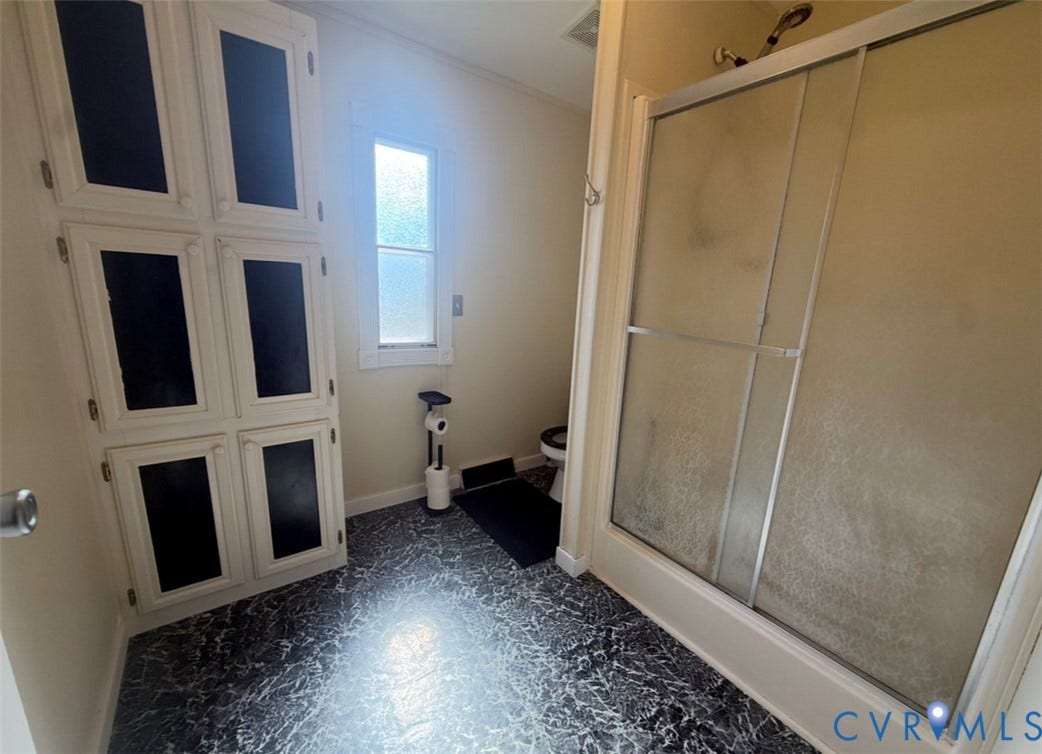 26691 Bell Road, Amelia, VA 23002 Built-in floor-to-ceiling cabinetry with multi-pane cabinet doors, walk-in shower with sliding glass enclosure, and patterned stone-finish flooring