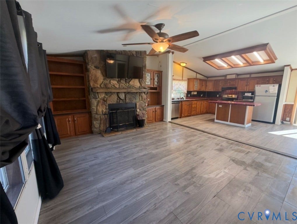 26691 Bell Road, Amelia, VA 23002 Floor-to-ceiling stone fireplace with built-in cabinetry, wood-finish flooring, central island, and wood cabinetry
