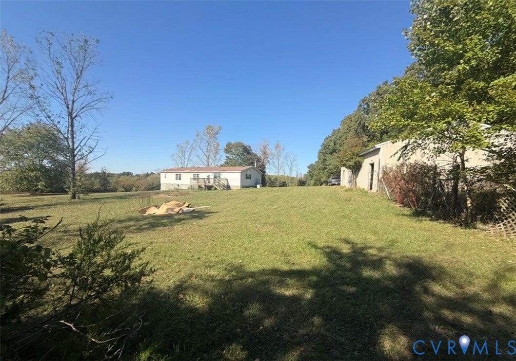 26691 Bell Road, Amelia, VA 23002 Expansive grounds featuring open grass fields, mature trees, and an auxiliary structure