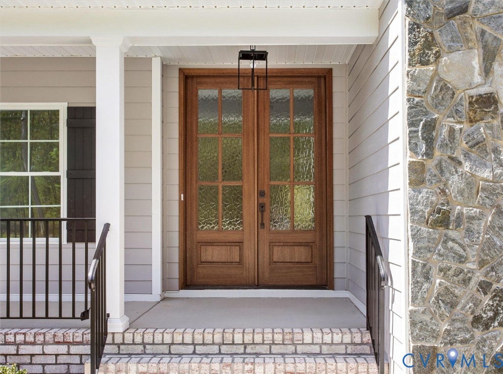 2851 Old Pump Road, Preserve At John Rolfe, Henrico, VA 23233 Double front entry doors with wood finish and seeded glass panes, stone veneer facade, brick-trimmed porch steps, and metal railing