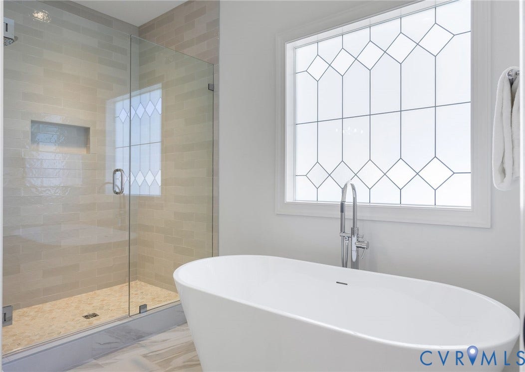 2851 Old Pump Road, Preserve At John Rolfe, Henrico, VA 23233 Freestanding soaking tub with a floor-mounted faucet, glass-enclosed shower featuring a recessed wall niche, and decorative window glass