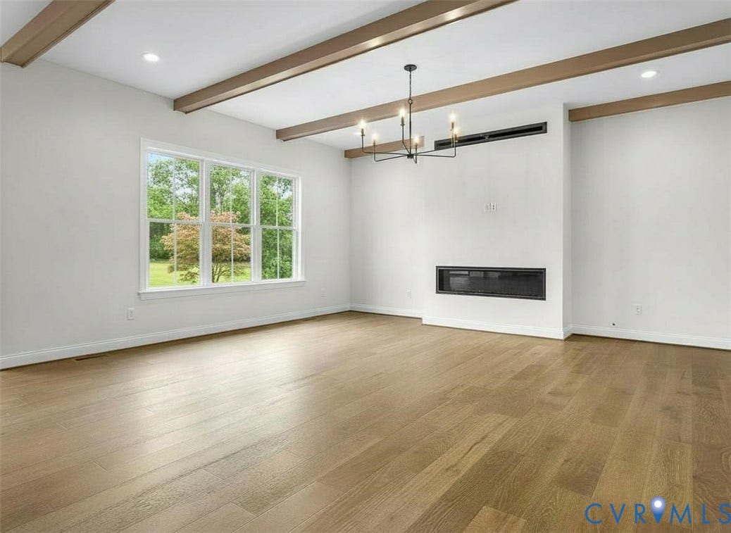 2851 Old Pump Road, Preserve At John Rolfe, Henrico, VA 23233 Living area featuring wood-finish flooring, exposed ceiling beams, a linear wall-mounted fireplace, and a multi-arm chandelier