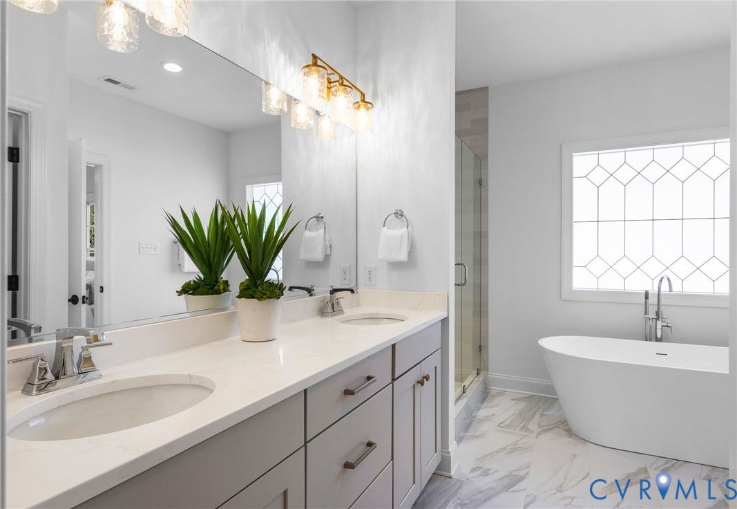 2851 Old Pump Road, Preserve At John Rolfe, Henrico, VA 23233 Double vanity with a light-colored countertop and dual under-mount sinks, freestanding soaking tub, glass-enclosed shower, and large-format tile flooring