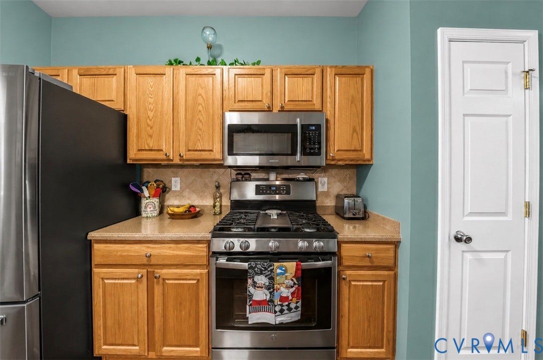 958 Wellston Court, Henrico, VA 23059 Kitchen featuring wood cabinetry, stainless steel gas range, over-the-range microwave, solid-surface countertops, and tiled backsplash