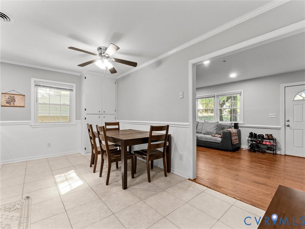 8708 Rainwater Road, Huntingcreek Hills, North Chesterfield, VA 23237 Dining area featuring large-format neutral tile flooring, built-in floor-to-ceiling cabinetry, chair rail molding, and a multi-blade ceiling fan with integrated lighting