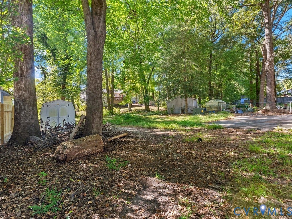 8708 Rainwater Road, Huntingcreek Hills, North Chesterfield, VA 23237 Expansive wooded lot featuring mature trees, a detached storage structure, and a fenced perimeter