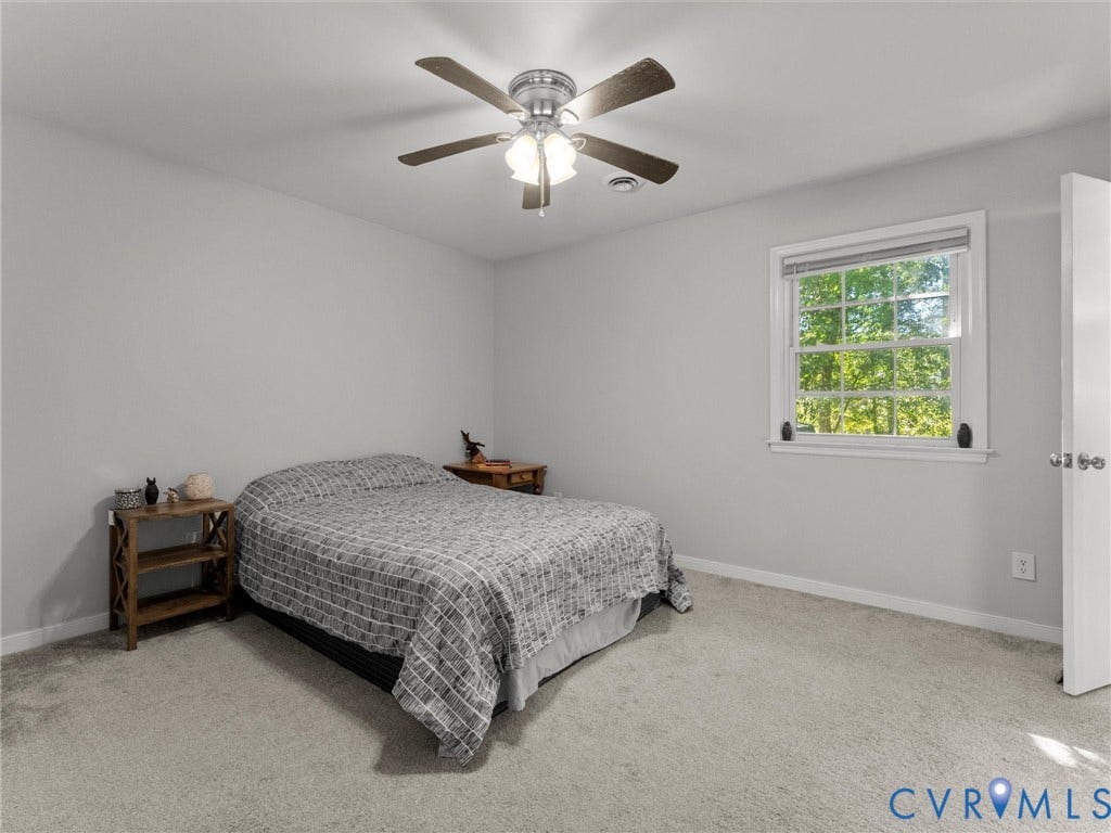 8708 Rainwater Road, Huntingcreek Hills, North Chesterfield, VA 23237 Neutral-toned interior space featuring wall-to-wall carpeting, a multi-blade ceiling fan with integrated lighting, and a double-hung window