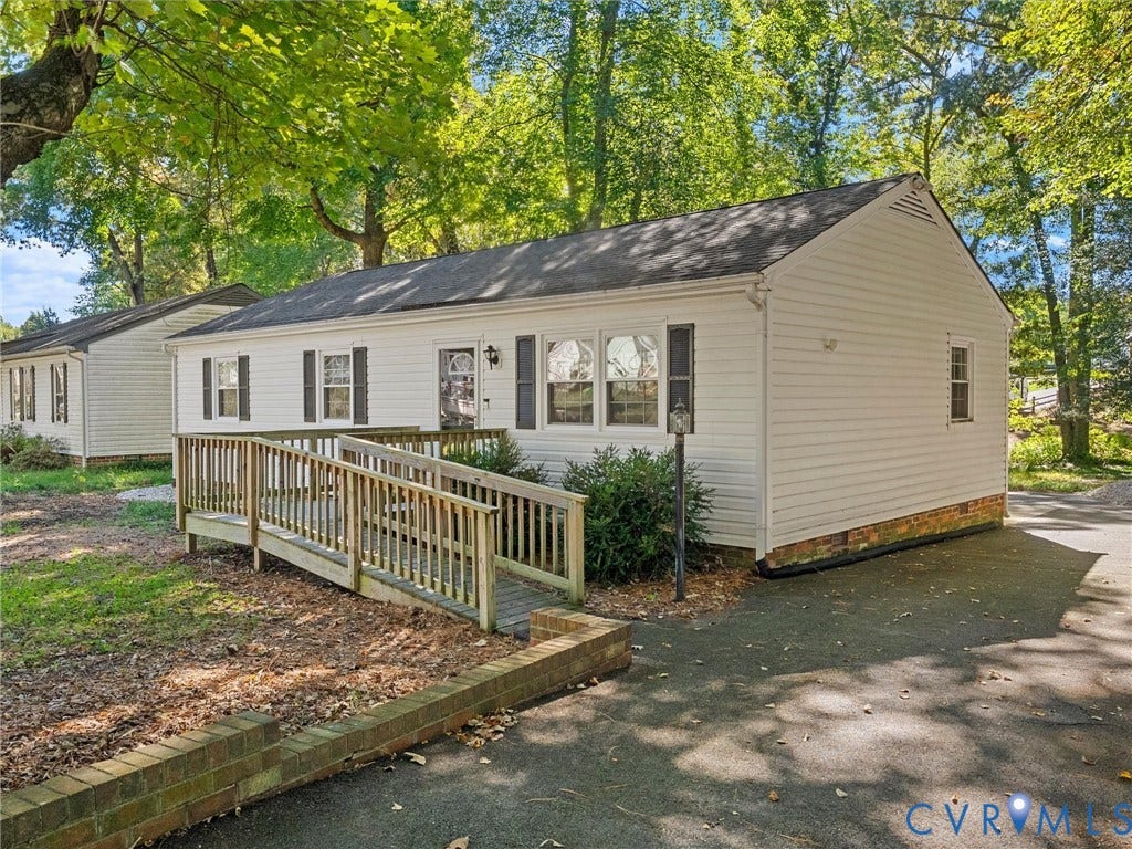 8708 Rainwater Road, Huntingcreek Hills, North Chesterfield, VA 23237 Single-story residence featuring light-colored horizontal siding, a pitched roof, dark shutter accents, an attached wood-railing ramp, and a brick-bordered asphalt driveway