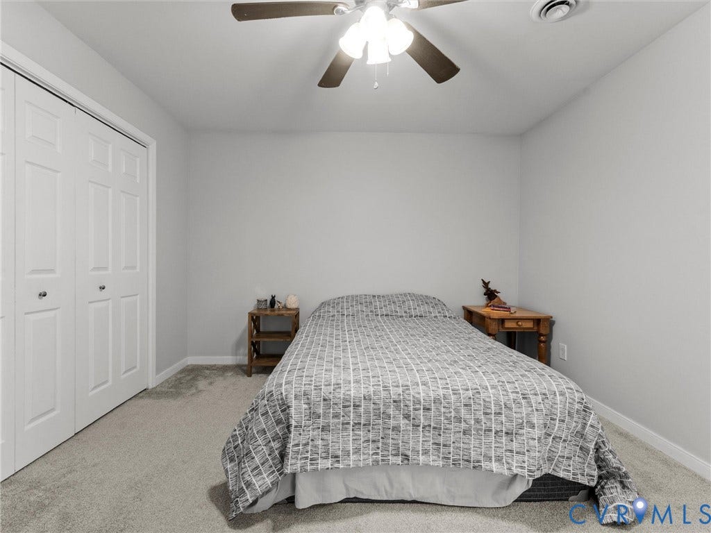 8708 Rainwater Road, Huntingcreek Hills, North Chesterfield, VA 23237 Neutral-toned room featuring neutral wall-to-wall carpeting, white dual-panel closet doors, and a ceiling-mounted light fixture with a multi-blade fan