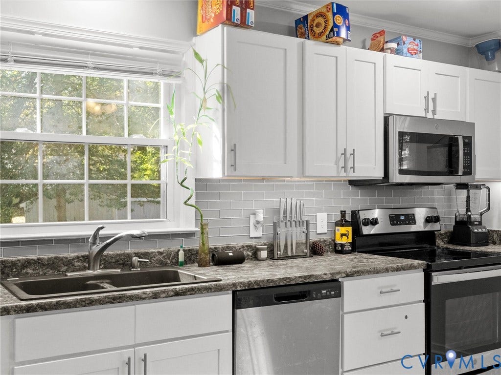 8708 Rainwater Road, Huntingcreek Hills, North Chesterfield, VA 23237 Kitchen featuring white shaker-style cabinetry, a gray subway tile backsplash, stone-finish countertops, stainless steel appliances, and a double-basin sink