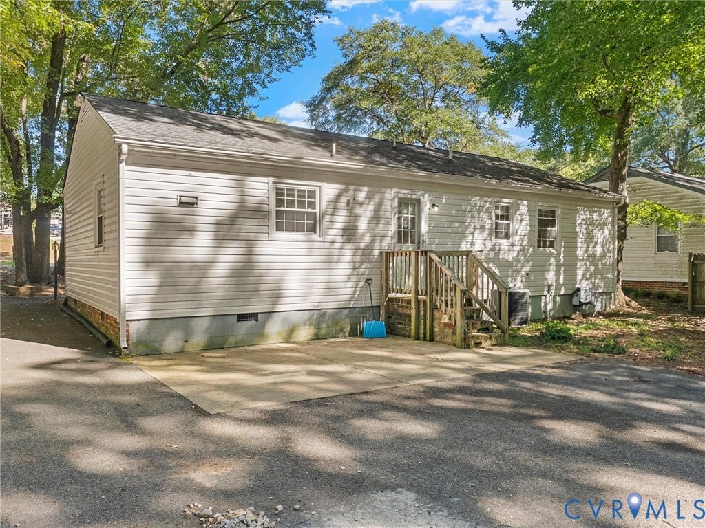 8708 Rainwater Road, Huntingcreek Hills, North Chesterfield, VA 23237 Light-colored vinyl siding exterior, concrete patio surface, timber-constructed staircase, and asphalt paved driveway