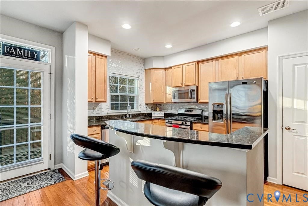 11600 Vicars Ridge Lane, Henrico, VA 23059 Kitchen with visible vents, light wood-style flooring, light brown cabinetry, a sink, and stainless steel appliances