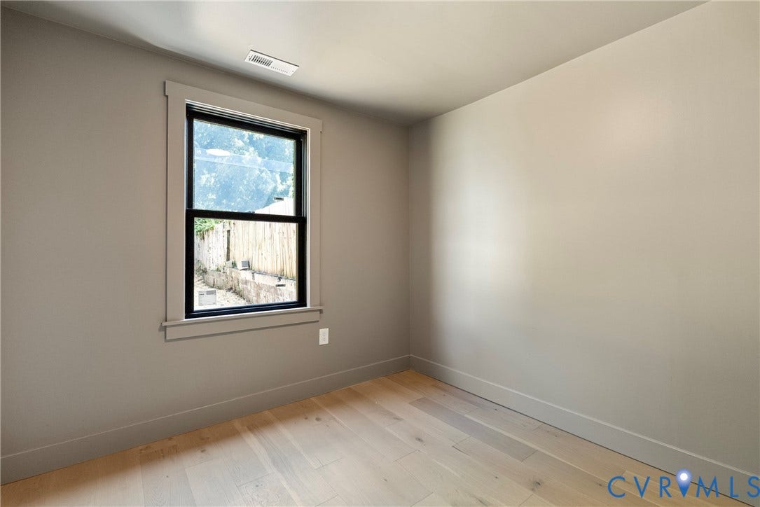 1708 Decatur Street, Swansboro, Richmond, VA 23224 Neutral-toned walls paired with light wood-finish flooring and a single-hung window featuring a dark frame
