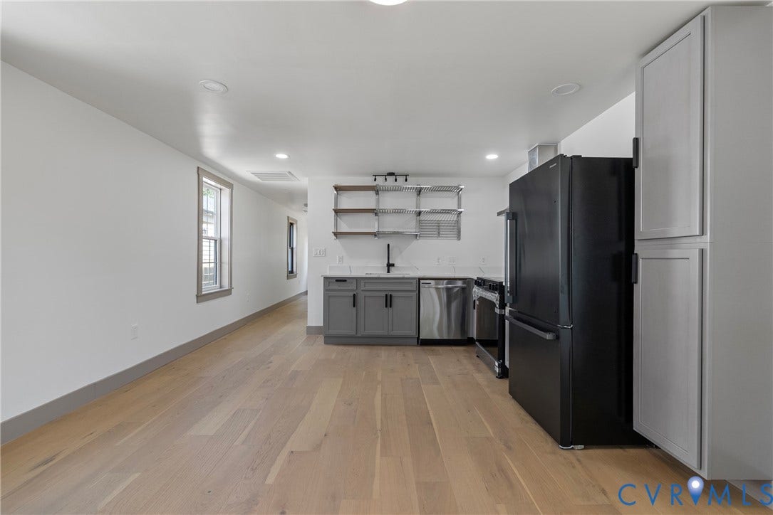 1708 Decatur Street, Swansboro, Richmond, VA 23224 Kitchen featuring wood-finish flooring, charcoal shaker-style cabinetry, matte black hardware, stainless steel appliances, and open wall-mounted shelving