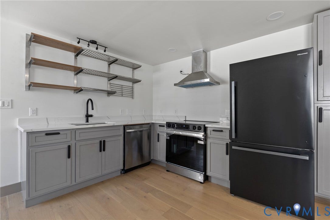 1708 Decatur Street, Swansboro, Richmond, VA 23224 Kitchen featuring light gray shaker-style cabinetry, white countertops with matching backsplash, stainless steel appliances, wood-finish flooring, and open metal shelving
