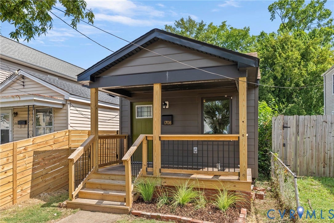 1708 Decatur Street, Swansboro, Richmond, VA 23224 Exterior featuring horizontal siding, a covered front porch with natural wood posts and railings, black metal balusters, and a solid-color entry door with an upper glass pane